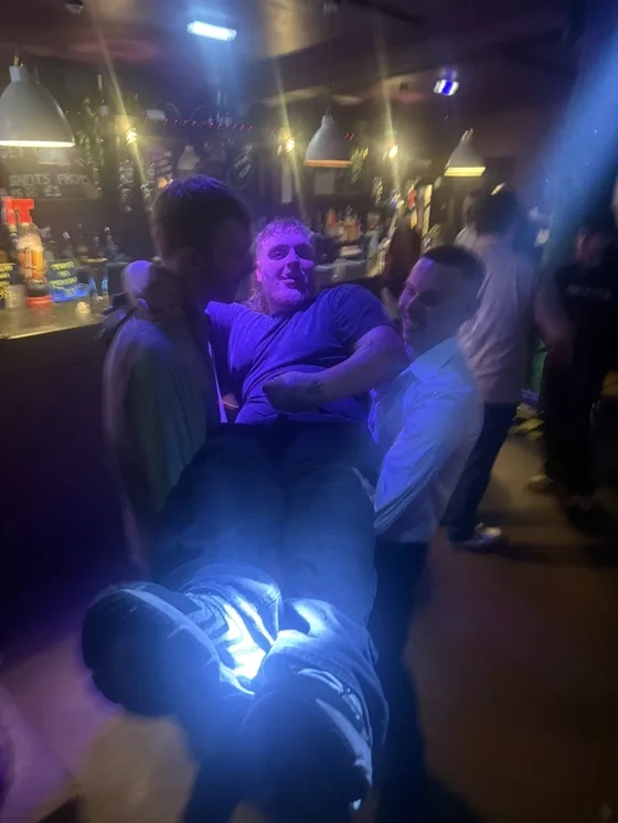 A busy bar floor under blue light