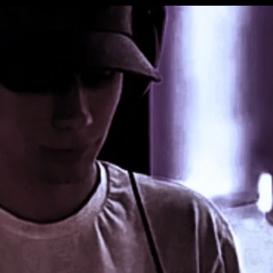 JBVII close up in a cap, backlit in the dark